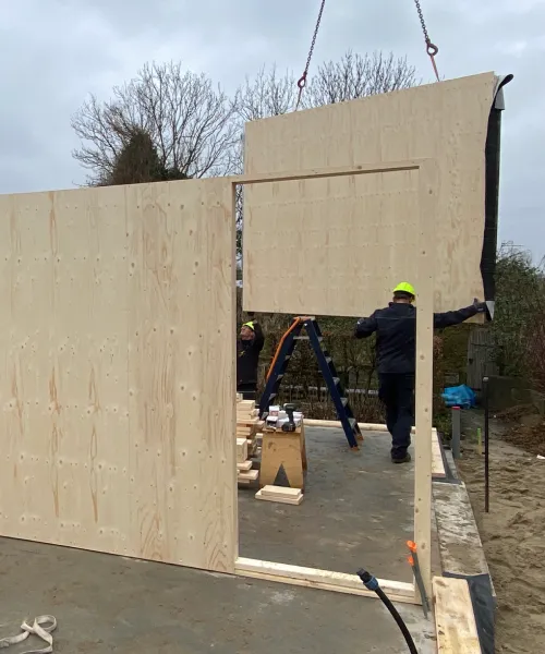 Montage van een prefab houtskeletbouw wandelement op de bouwplaats